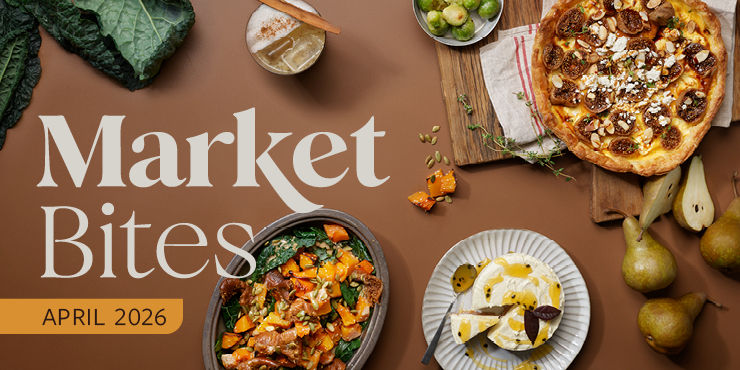Various dishes like pizza and salad on a brown table with pears and kale. Text reads "Market Bites April 2026" in elegant font.