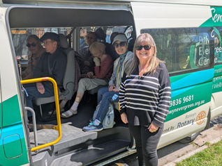 Woman standing in front of minivan smiling