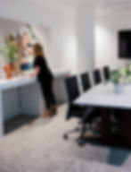 Boardroom table surrounded by chairs and a display space for interior design fabrics