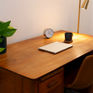 A desk at Connected Minds Collingwood clinic with a laptop, tea, clock and a lovely green plant.