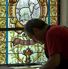Daniël Theys, een meester in restauratie van glas-in-lood, met decennialange ervaring in het restaureren van glasramen.