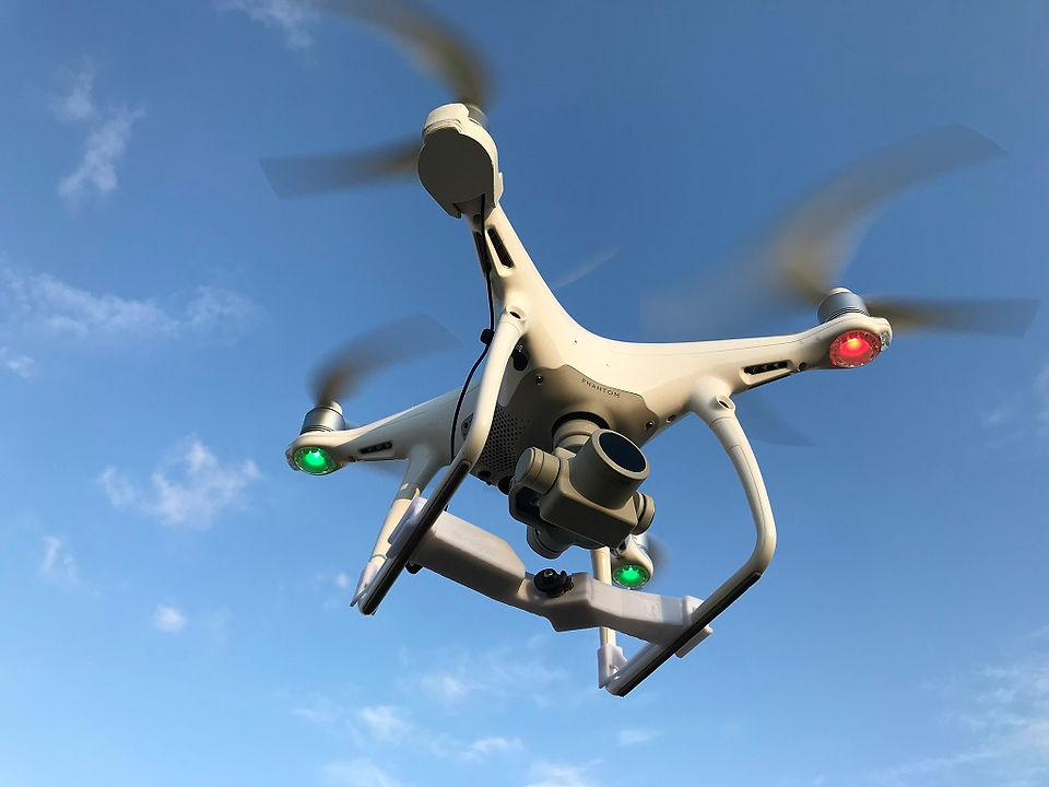 A DJI phantom 3 drone can be seen with active sensors and a camera attached to its bottom 