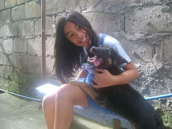 girl sitting on bench with black dog