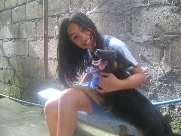 girl sitting on bench with black dog