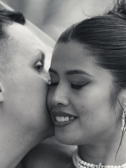 Gros plan d'un marié embrassant la joue de la mariée avec tendresse.