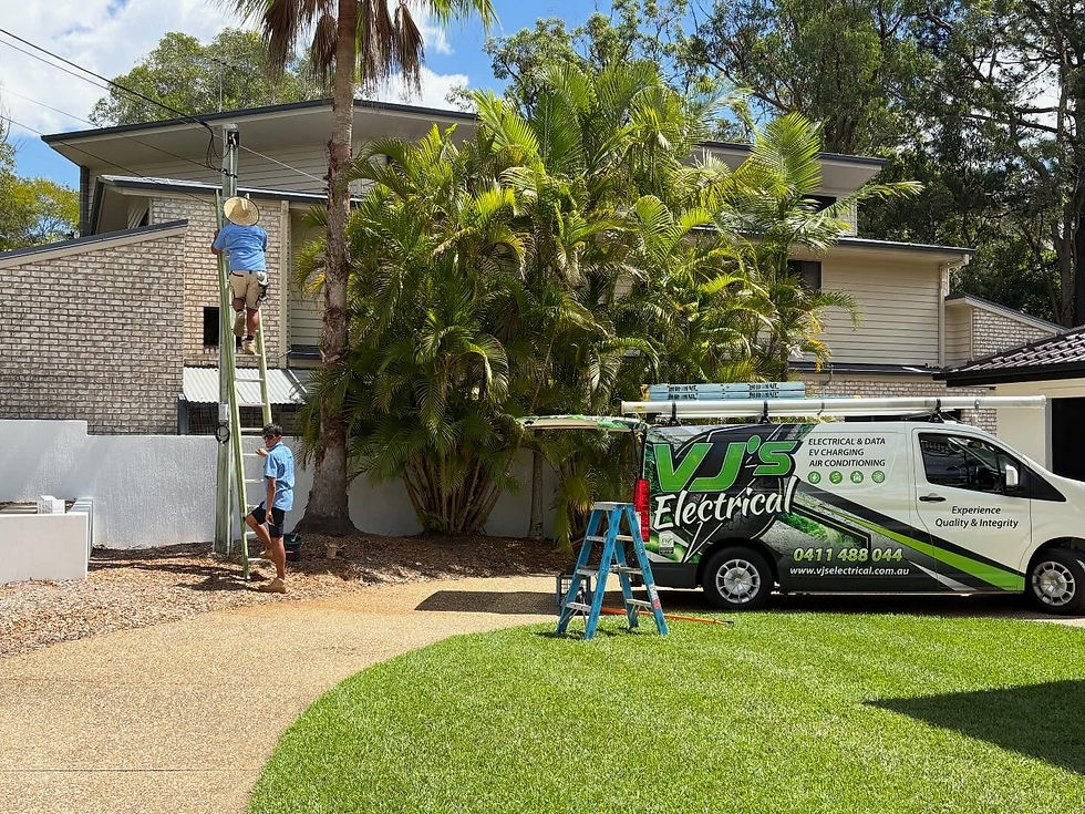 Brisbane Electrician on a ladder at a house, VJS Electrical van