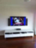 Professional TV wall mounting with speakers and media console.