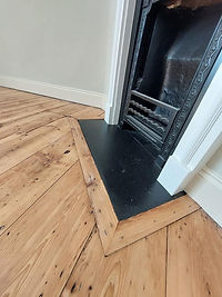 Floor restoration detail around fire surround.