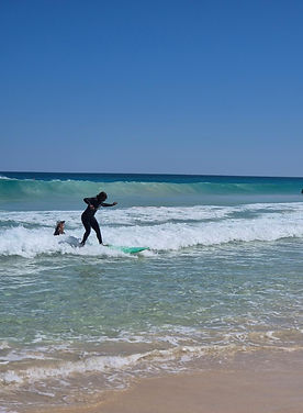 alt="Diana McKay on a beautiful beach with blue ocean and sky."