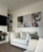 A neutral living room with abstract artwork bespoke cabinetry and boucle sofas