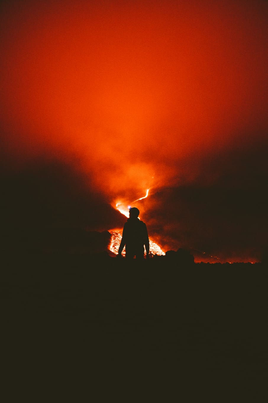 Silhouette of a person facing a volcanic eruption, symbolizing the first steps when a crisis is approaching.