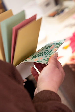 Hand holding colorful book with floral patterned page.