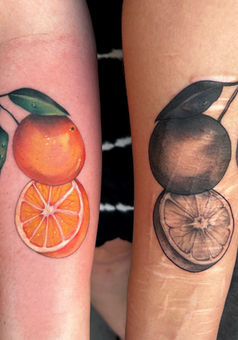 Matching orange tattoos on inner forearms