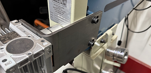 Metal bracket attaching an electric motor to a bead roller.