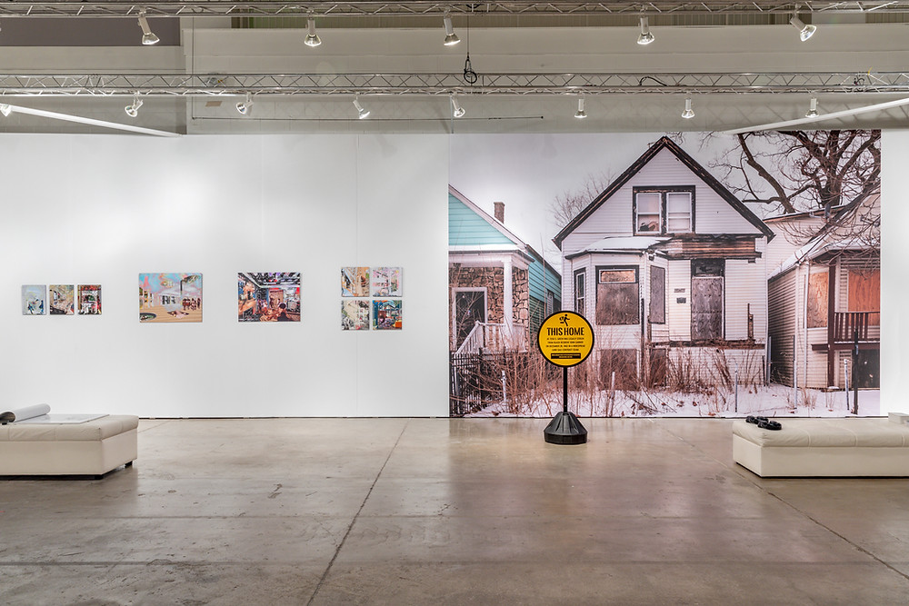 Photograph of an abandoned home with a yellow sign in front reading "This Home Was Legally Stolen from a Black Resident"