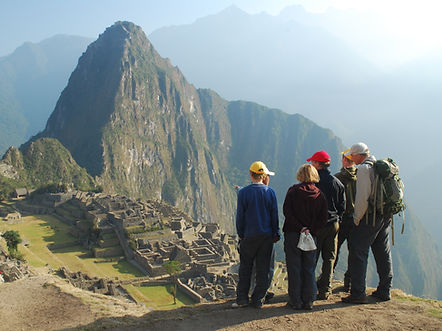 A family seen from behind admiring the breathtaking view of Machu Picchu.