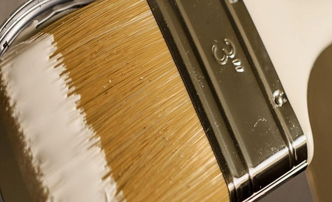 Paint brush with white paint on it