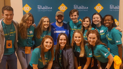 CSU Program Board Exec Team standing with Quinn XCII.