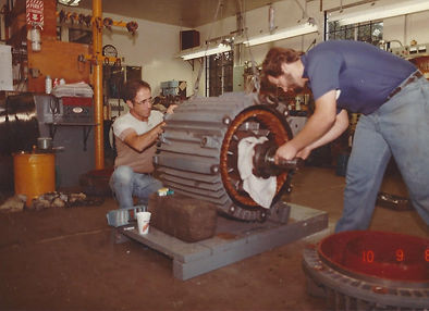 70's photo of technician's pulling shaft from electric motor in shop
