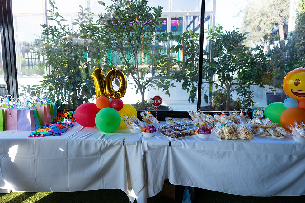 Colorful kids birthday party table at Nuevo Campo in Nicosia, decorated with balloons, snacks, and goodie bags.