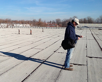 Service tech inspecting commercial flat roof