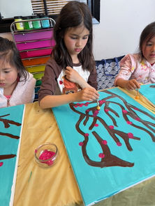 Child working on a large abstract painting, exploring colors in an Intelligent Learning afterschool art class.