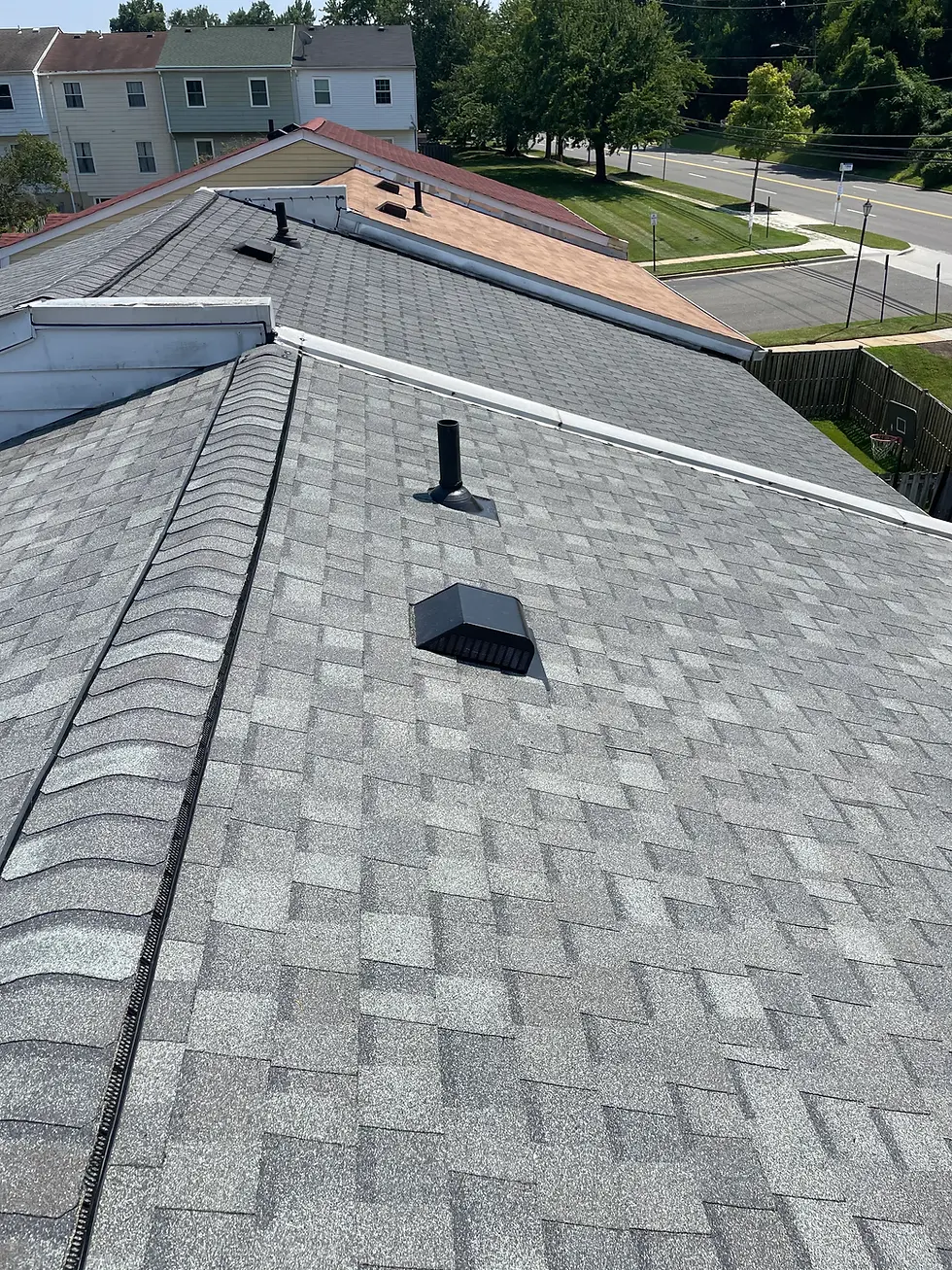gray-asphalt-shingle-roof-with-vents-and-adjoining-homes-visible-in-sunny-neighborhood-showing-finished-installation-related-to-roofing-warranties-explained