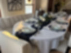 High angle view of an elegant tablescape with white plates, gold cutlery, and a floral centerpiece