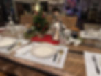 Eye-level view of a rustic wooden dining table with soft candlelight and autumn-themed decorations