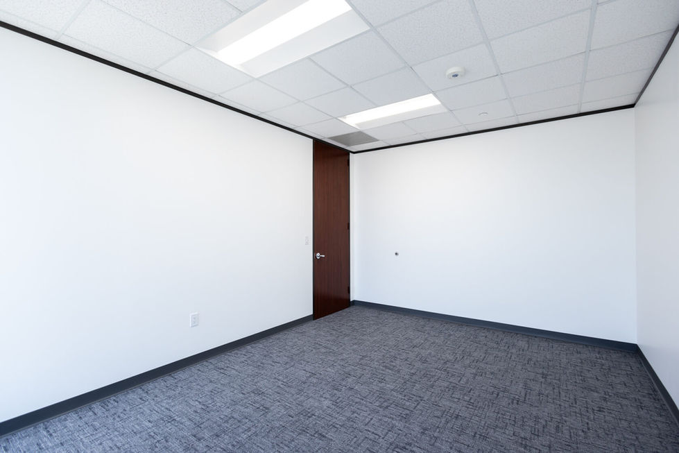 Empty office room with white walls and carpet.