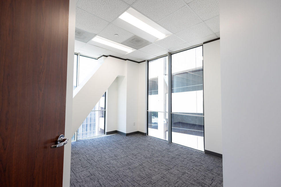 Bright, empty office space with large windows.