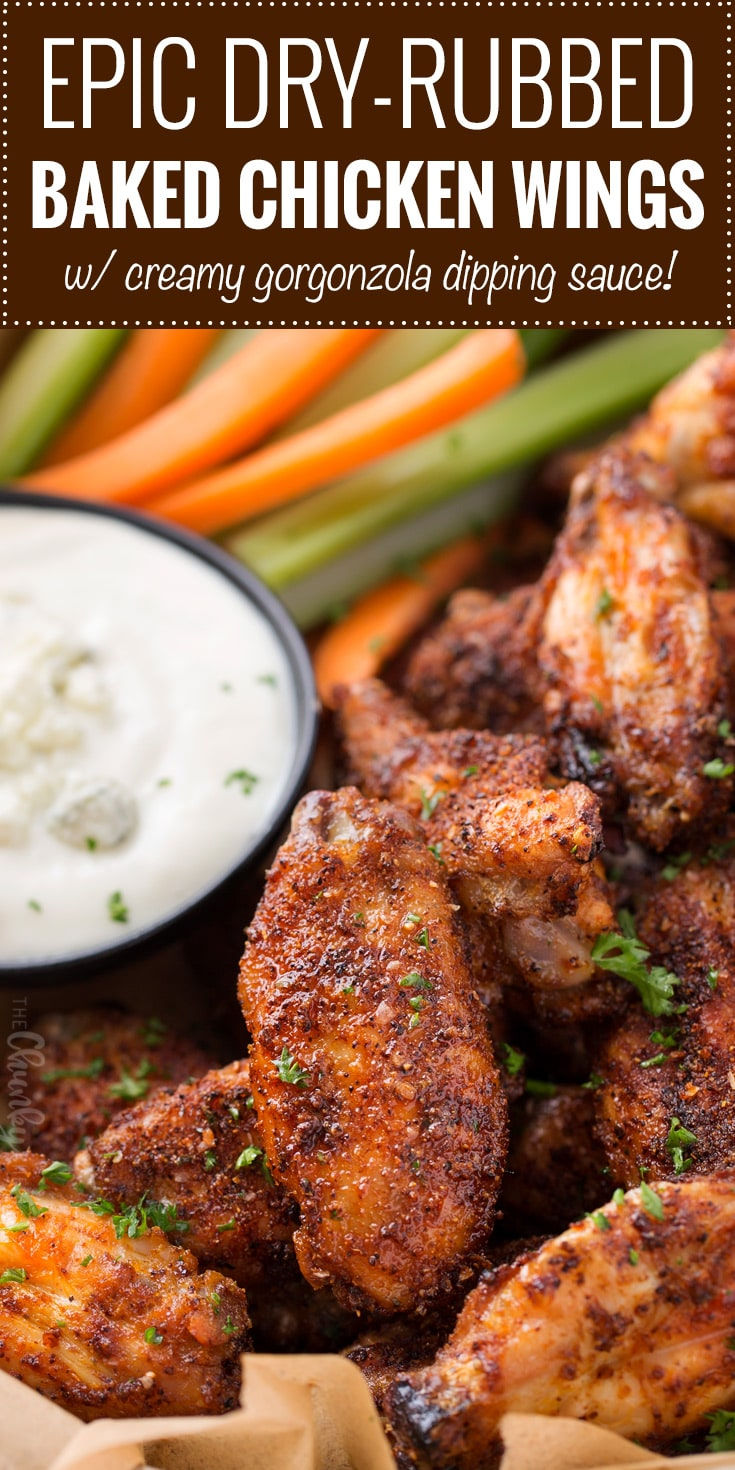 Savory and crispy dry-rubbed baked chicken wings served with a creamy Gorgonzola dipping sauce, garnished with fresh herbs and accompanied by crisp celery and carrot sticks.