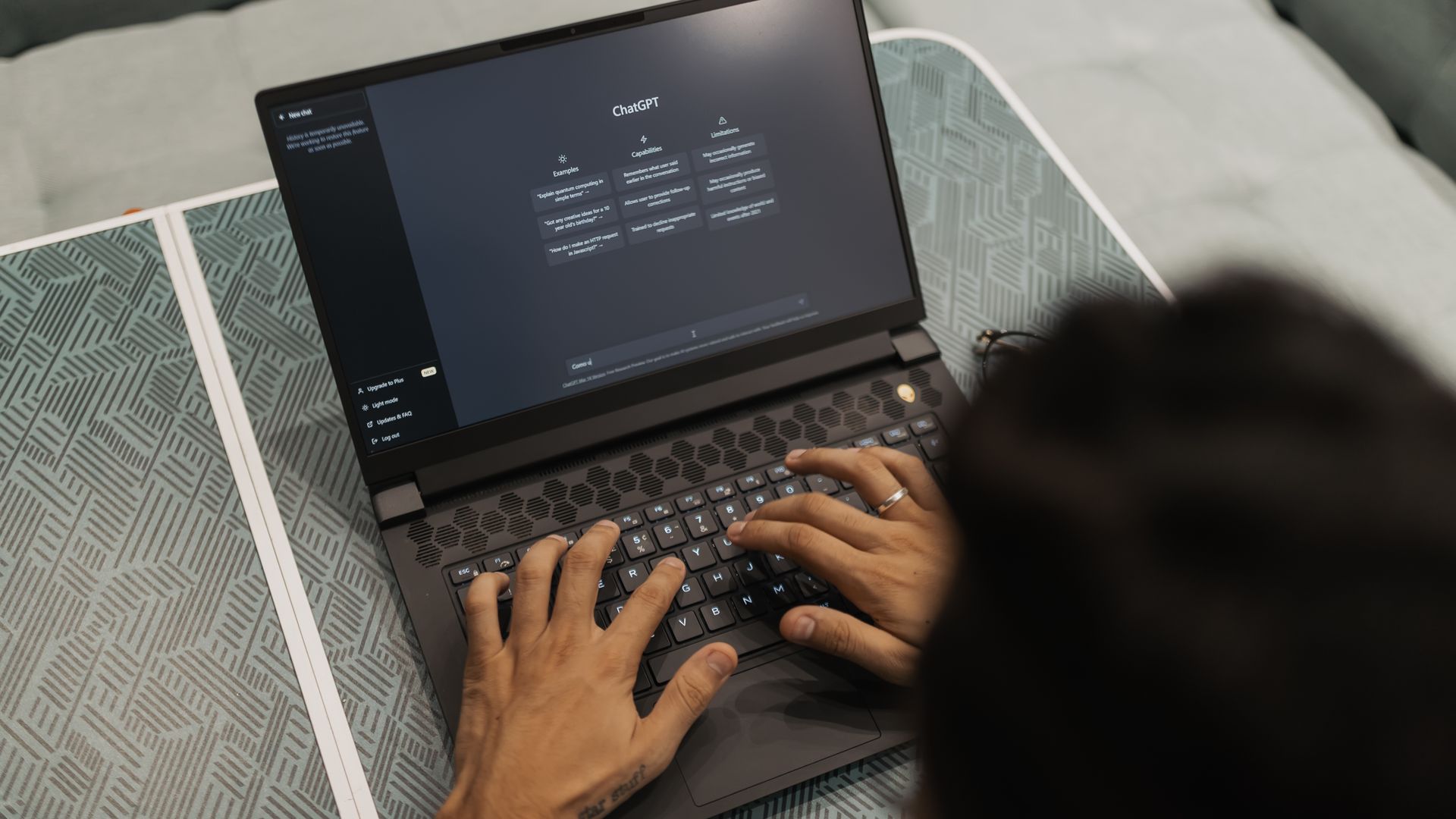 Foto 1920x1080 realista, sem texto e sem rosto, das mãos de um profissional digitando num notebook com uma ferramenta de chat de inteligência artificial aberta na tela. Alt: mãos digitando num notebook com uma ferramenta de inteligência artificial aberta na tela, ilustrando a equipe que já usa IA sem treinamento formal.