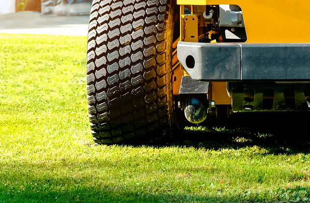 The yellow zero-turn mower parked in the