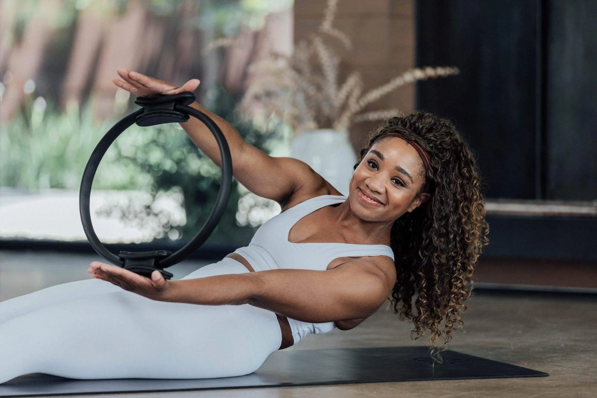 Person performing a chest press with a Pilates ring to strengthen arms, shoulders and chest.