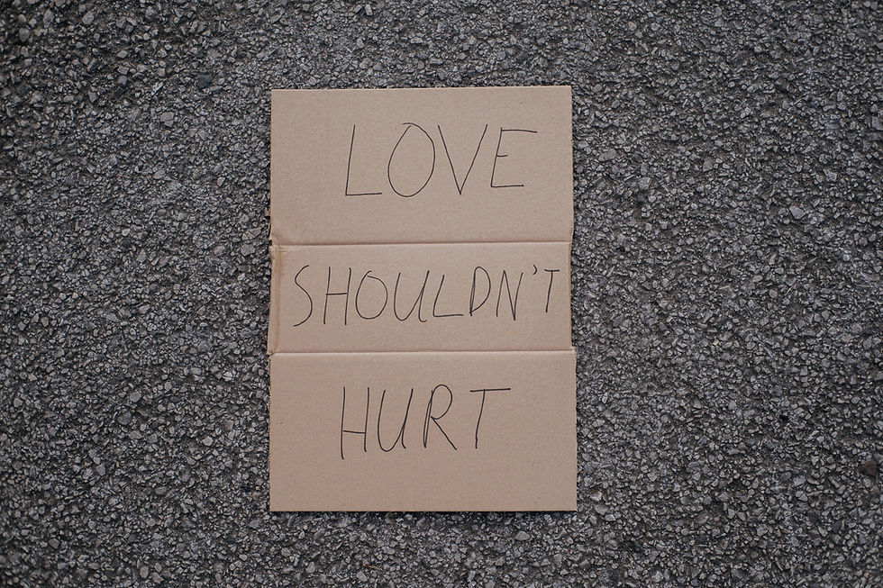Pappschild mit der Aufschrift „Love shouldn’t hurt“ als Symbol für narzisstischen Missbrauch