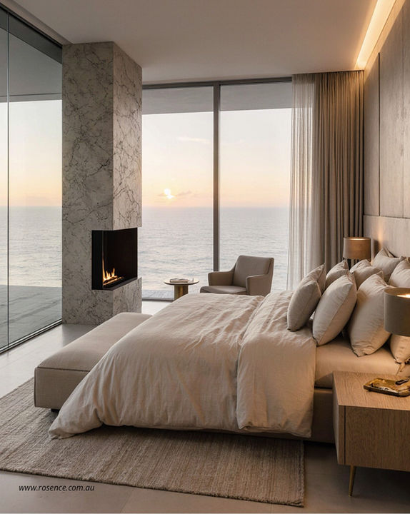 Serenity Crest bedroom featuring a fireplace and expansive ocean views. Minimalist design, natural materials, and soft lighting create a warm, relaxing atmosphere that connects the interior with the coastal landscape.
