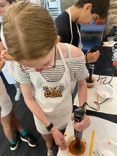 Another junior chef learns how to use the immersion blender.