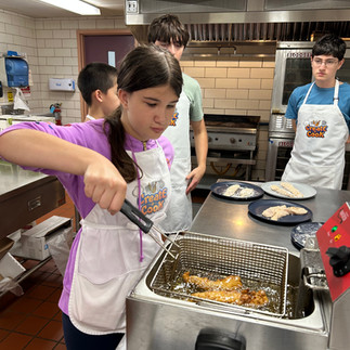 Junior chefs practice using the fryers for their Chicken and Waffles.