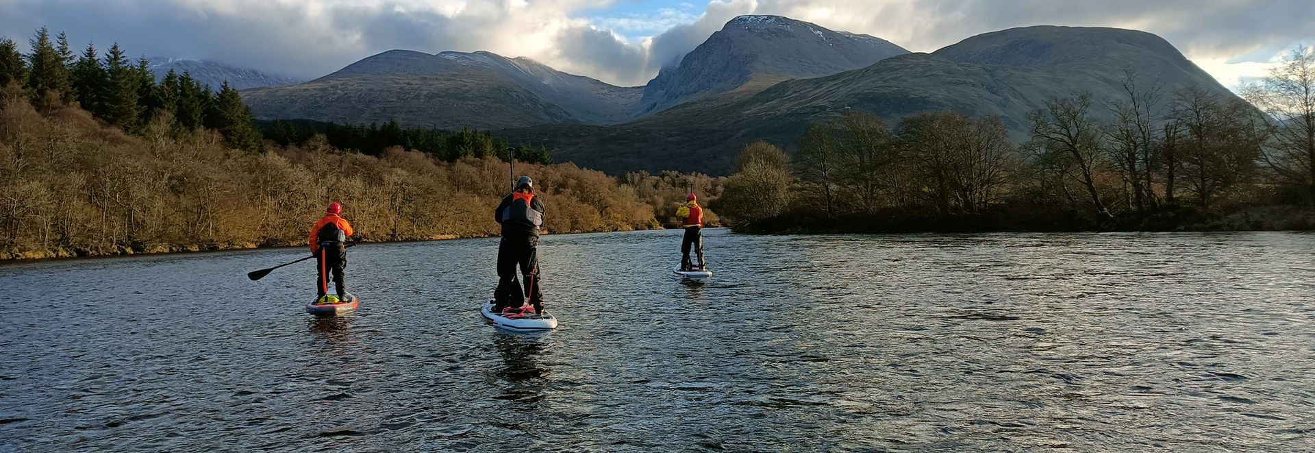 paddle boarder paddling with mountain in back ground