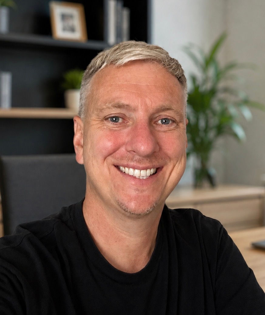 Portrait headshot of a smiling man in a black shirt