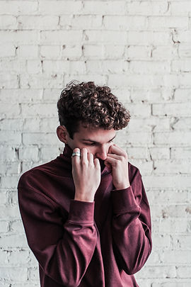 man with curly hair looking Down and to the left fatigued