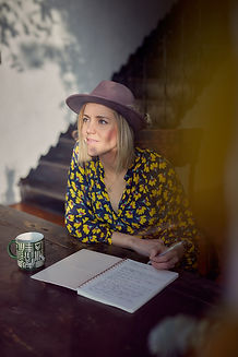 Women writing in a journal looking hopeful