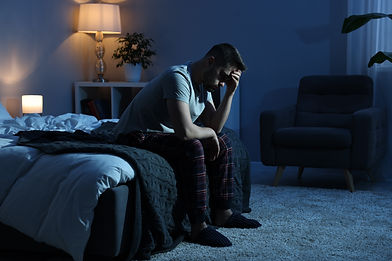 Frustrated man sitting on bed at night.jpg