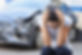 woman sitting on curb after a car crash