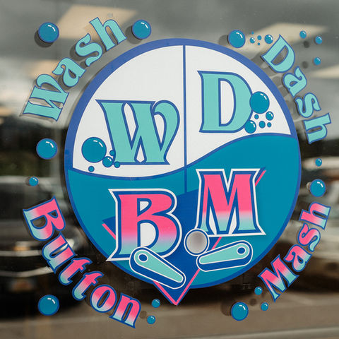 Wash Dash Button Mash logo and branding by Z Squared Studio on a window.