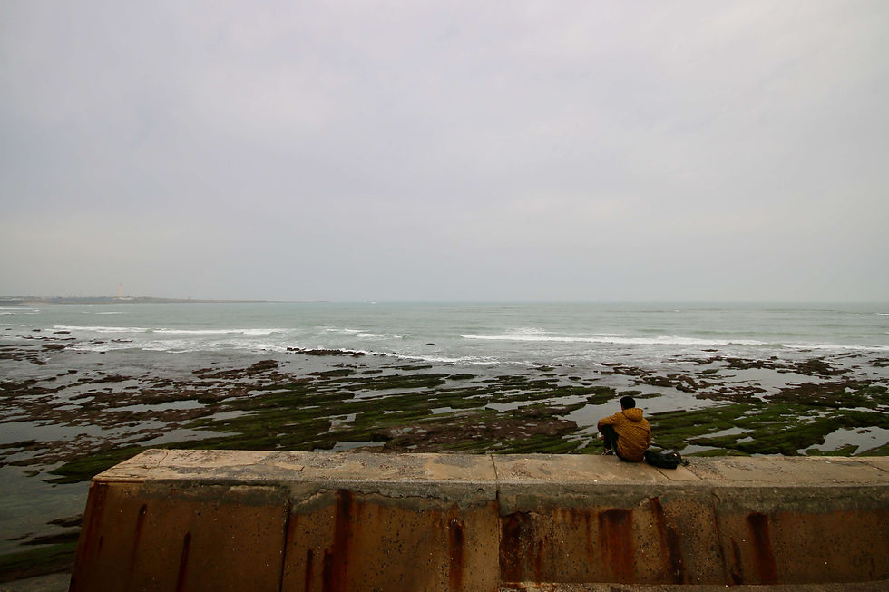 A young Moroccan looks out across the Atlantic Ocean from the Corniche in Casablanca