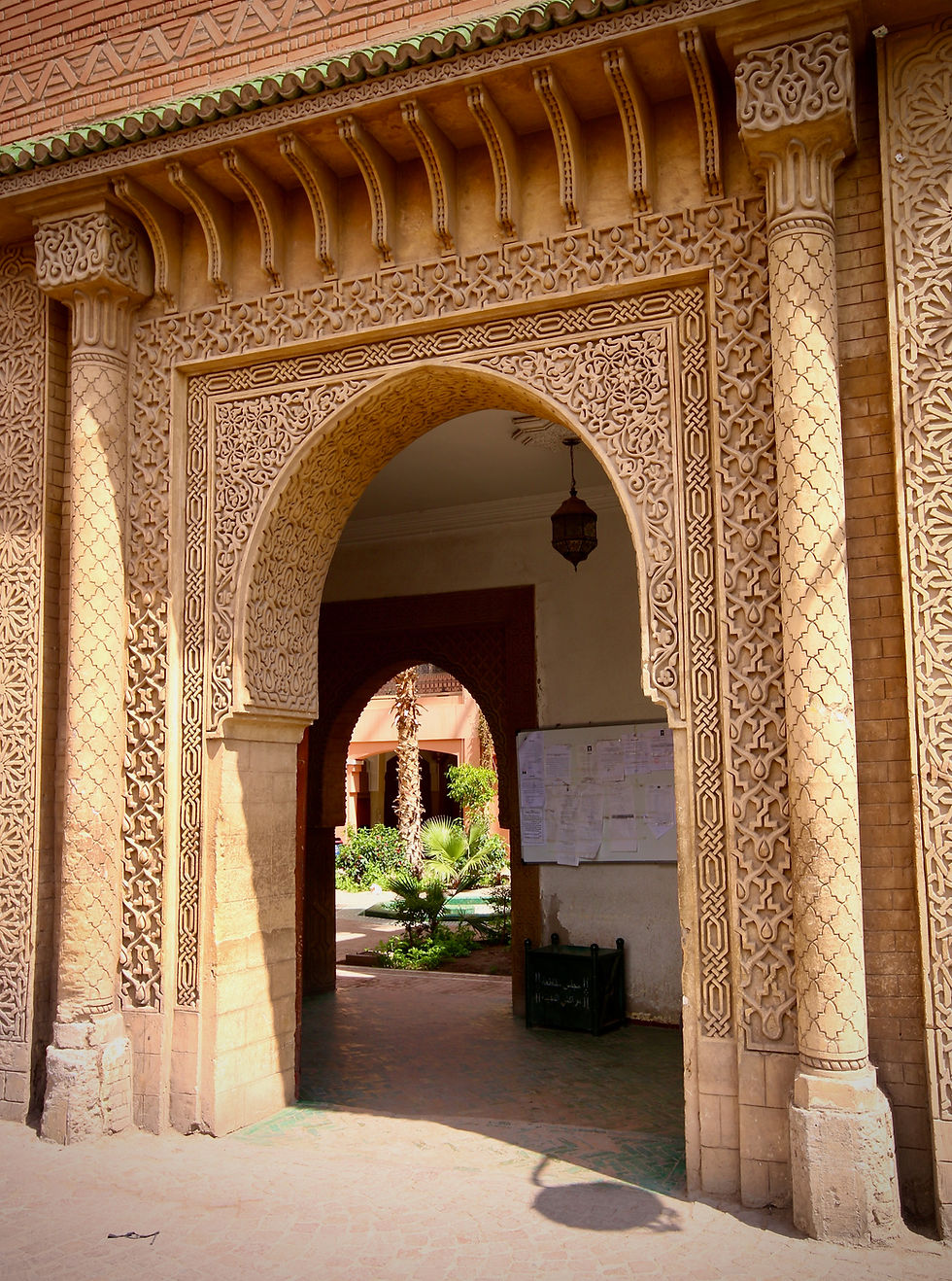 Looking through an ornate archway into an interior Marrakech garden