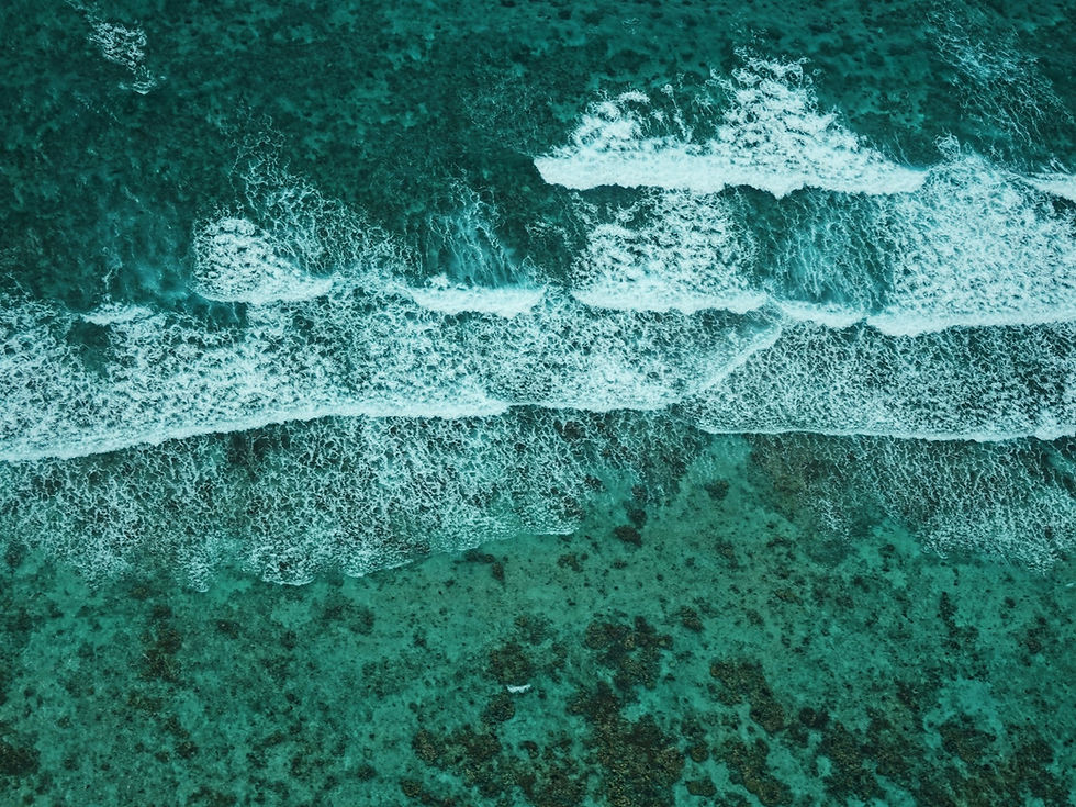 An aerial view of waves breaking along a reef off the coast of Belize