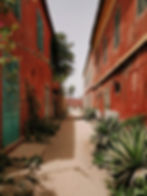 Ochre buildings line a laneway on the UNESCO-listed island of Goree
